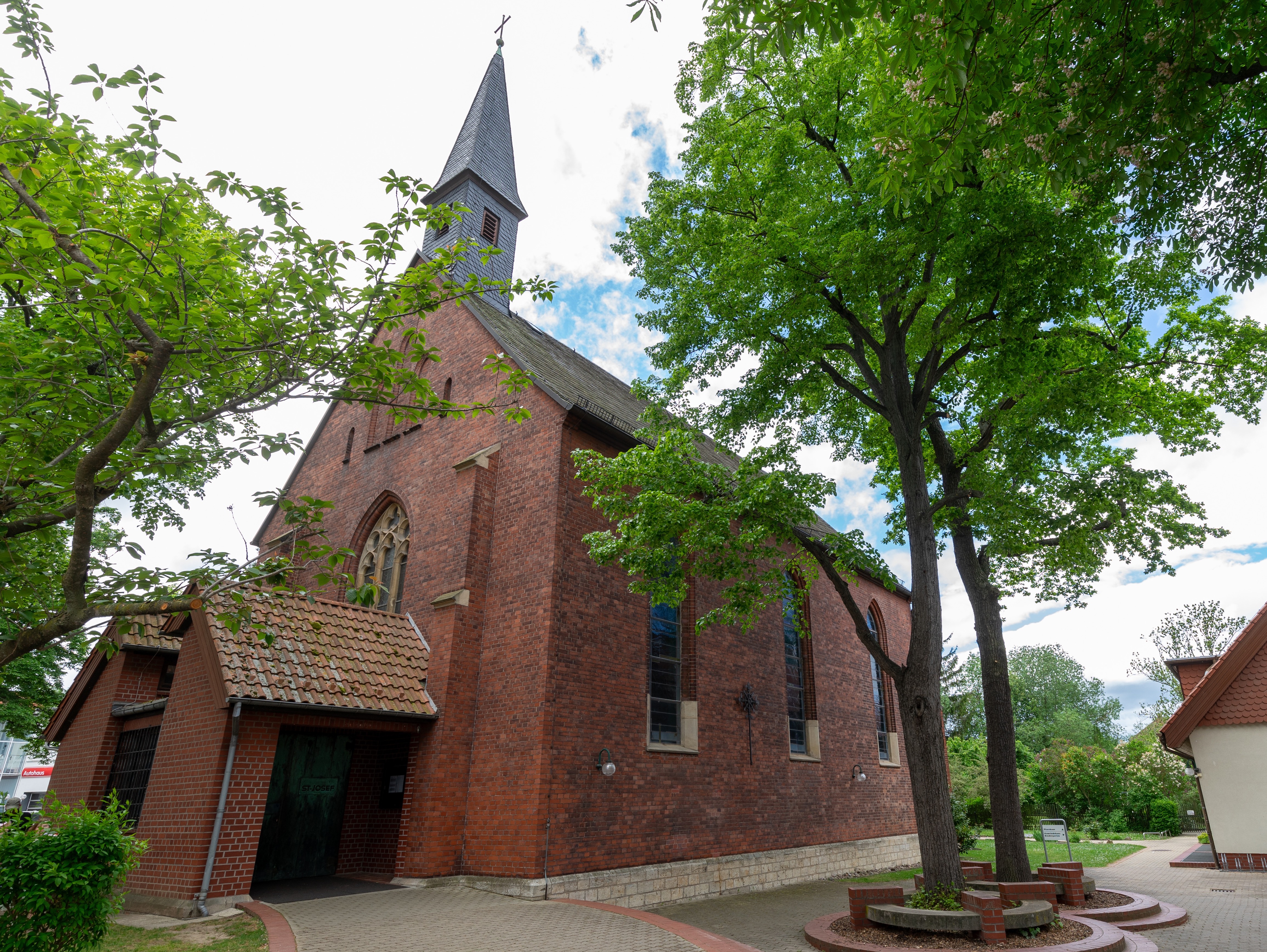 Kirchengebäude aus roten Backsteinen mit schwarzen Dachziegeln und kleinem Turm