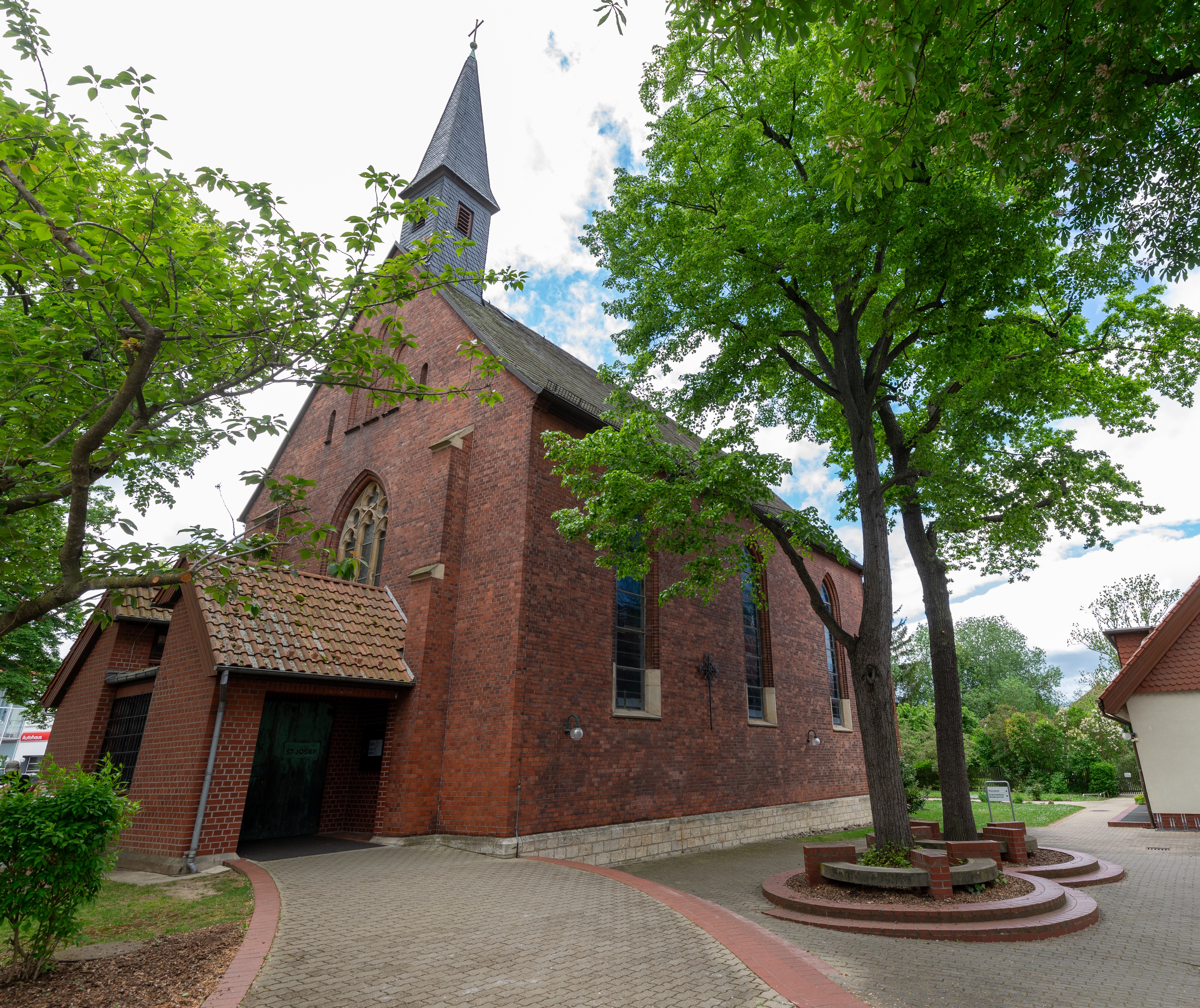 Kirchengebäude aus roten Backsteinen mit schwarzen Dachziegeln und kleinem Turm