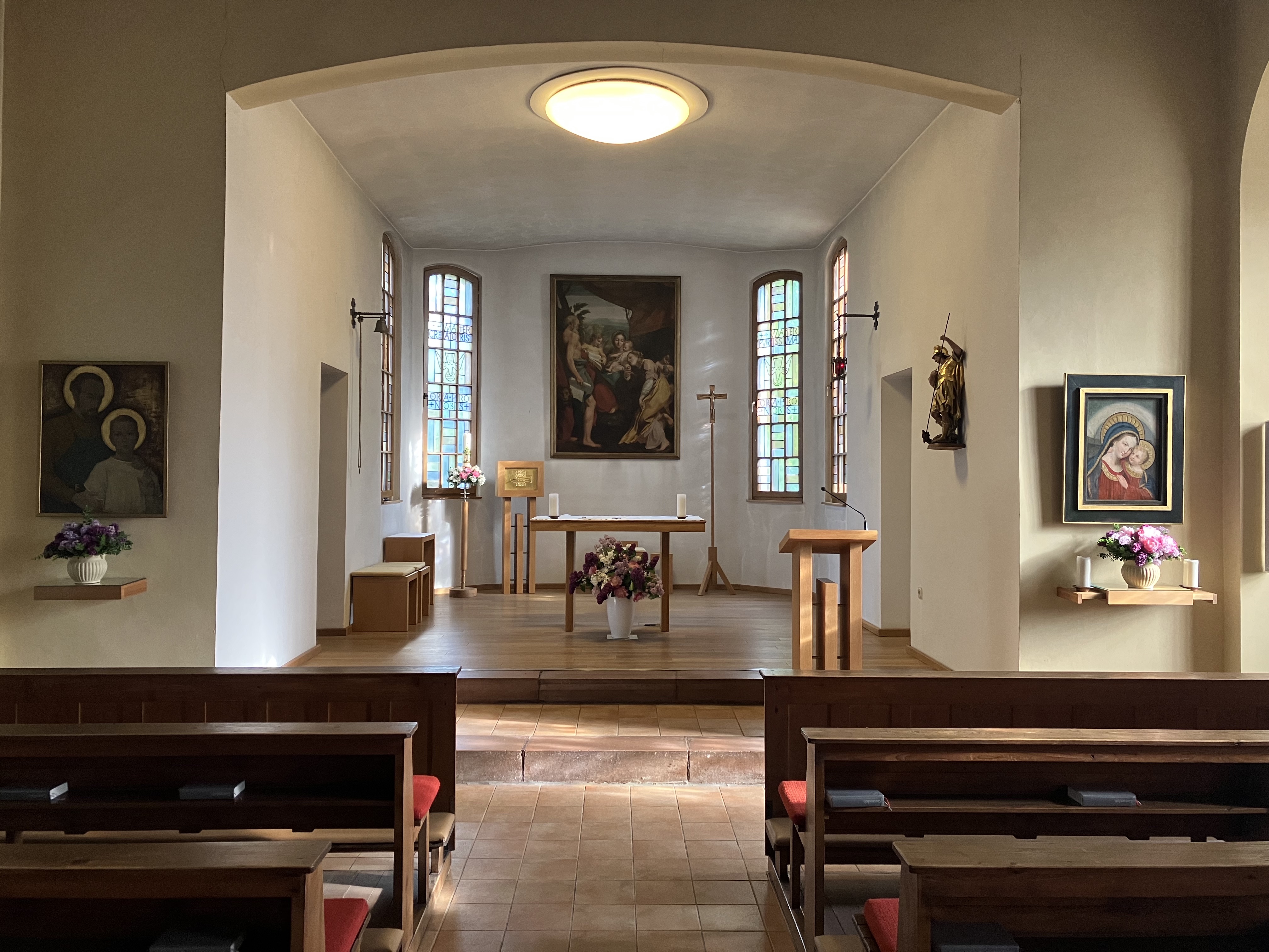 Innenansicht einer Kirche mit Bänken, Altar und Ambo