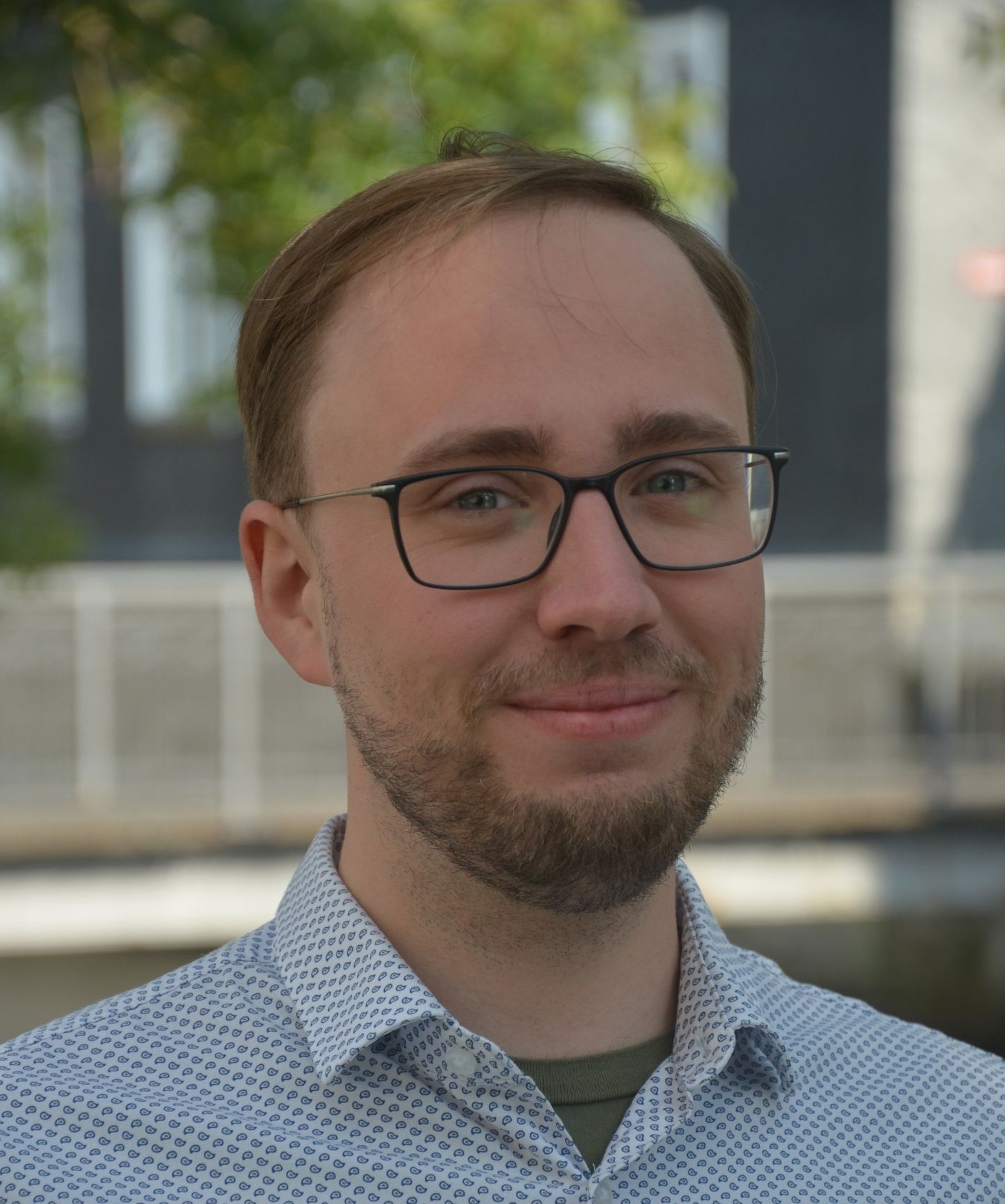 Gesicht eines Mannes mit Dreitagebart und Brille