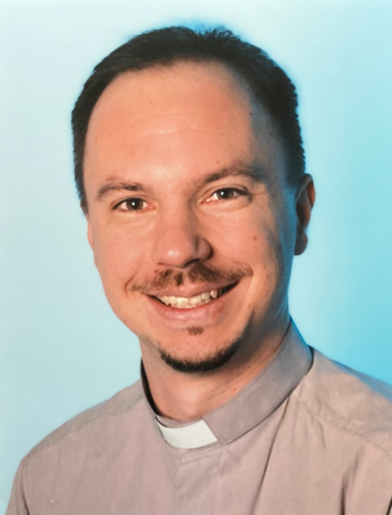 Mann mit Schnauzbart und grauem Kollarhemd