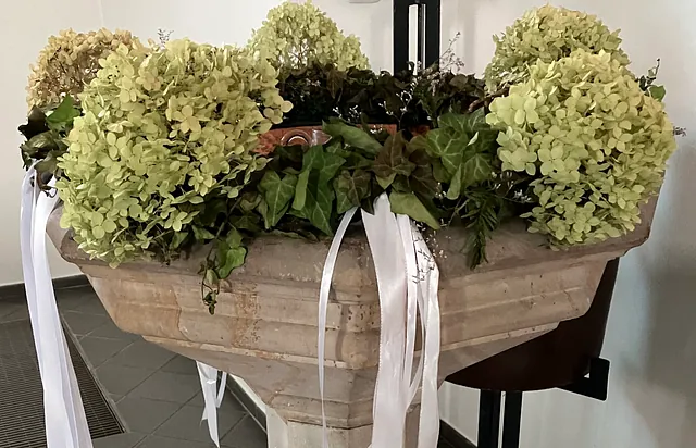 mit Blumen geschmücktes Taufbecken