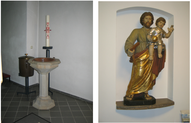 Osterkerze hinter einem Taufbecken, daneben eine Statue des heiligen Josef mit dem Jesuskind auf dem Arm