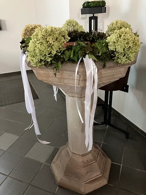 mit Blumen geschmücktes Taufbecken